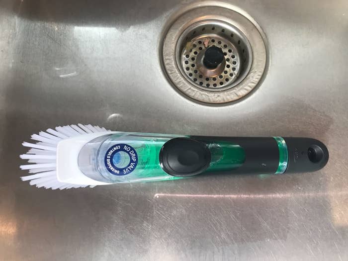 A reviewer&#x27;s photo of the brush filled with green soap