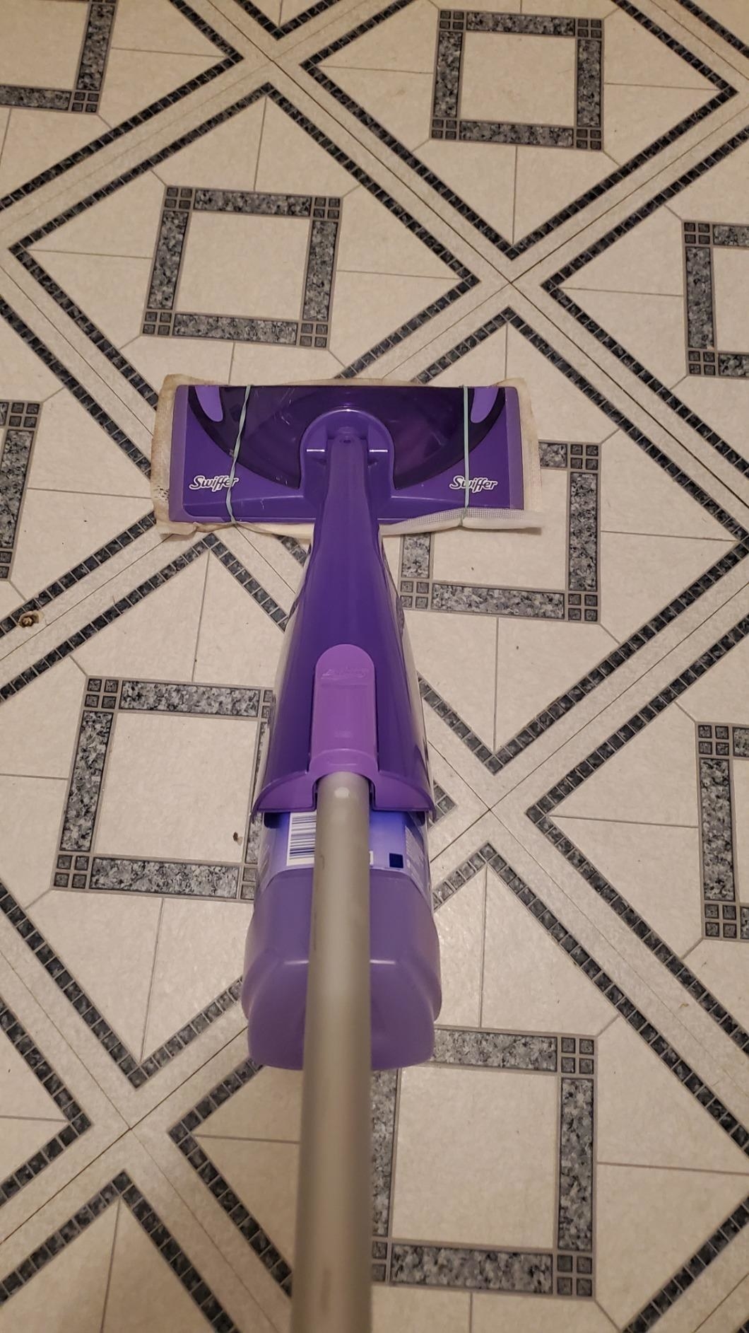 reviewer using the mop on a floor