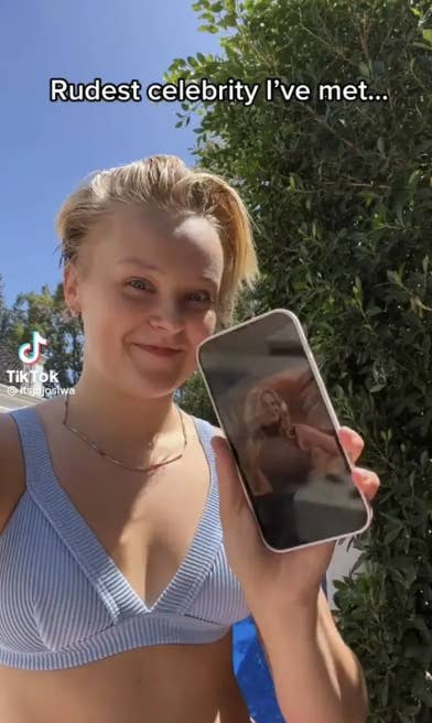 JoJo holding up her phone with a picture of Candace