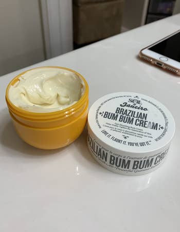 A reviewer's photo of the white product in a yellow jar