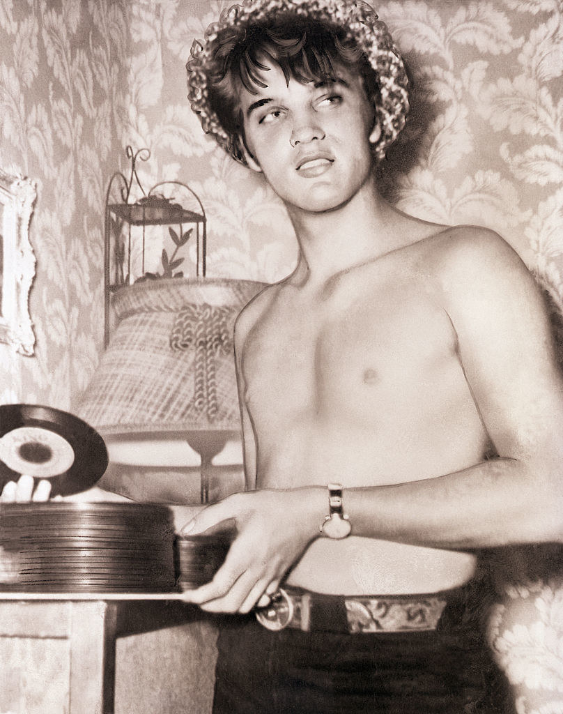 Elvis shirtless looking at records