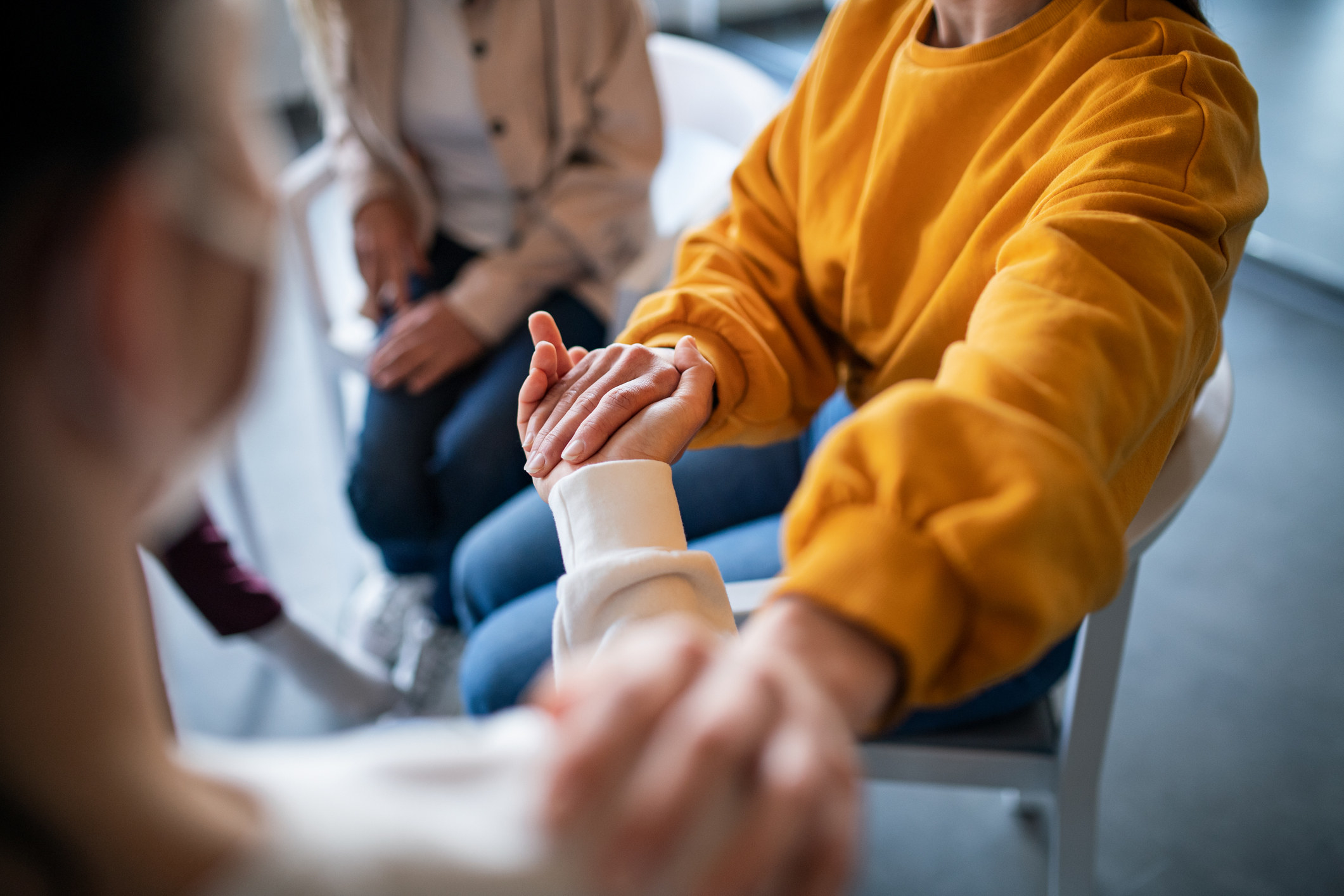 close up of people holding hands in a group