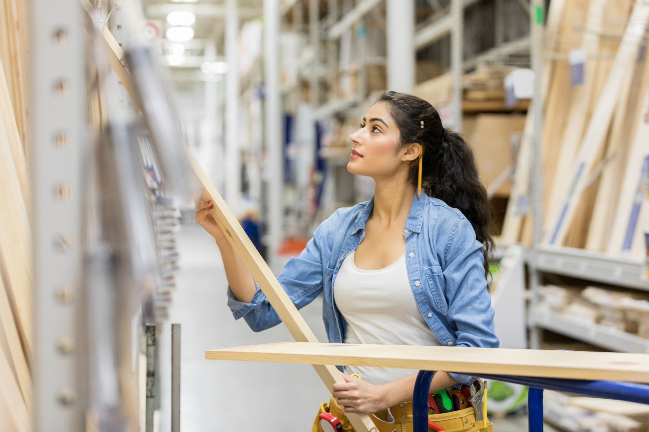 a woman working and pulling wood from the shelves