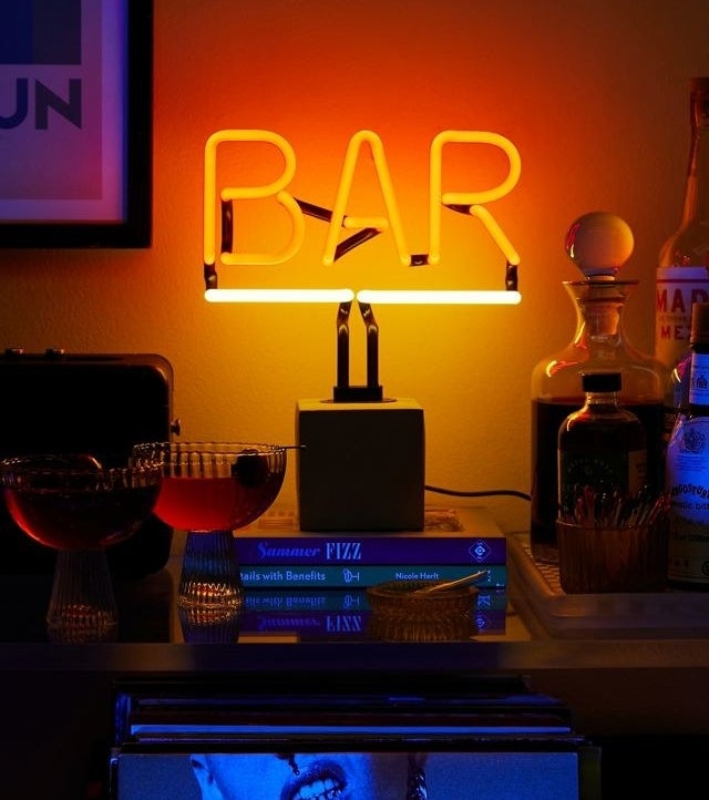 a neon bar sign on a surface in a dark room