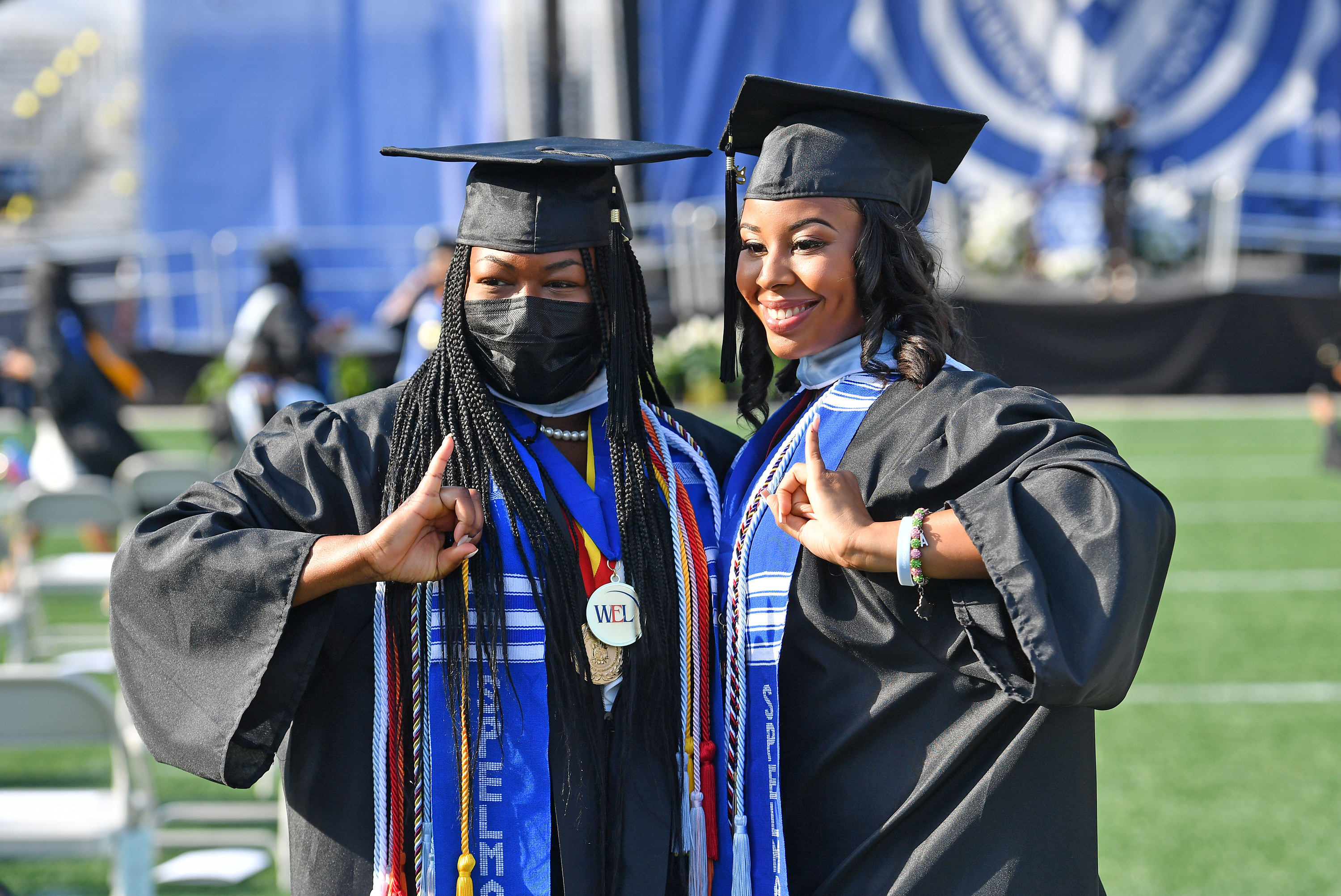two female students posing in their graduation gowns