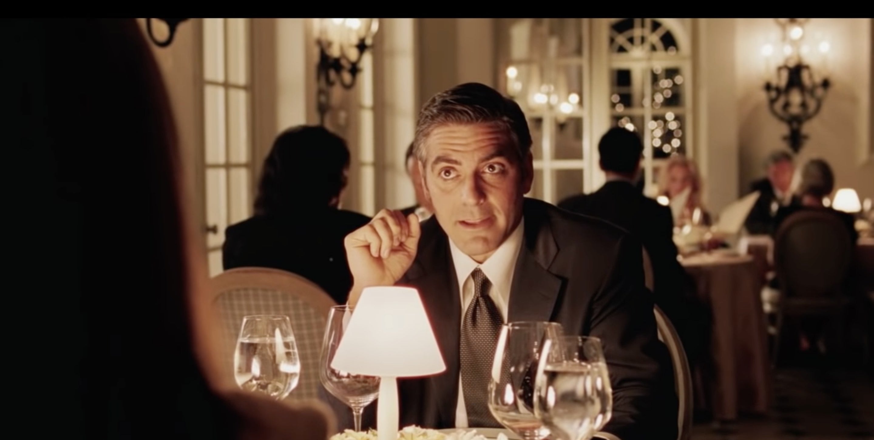 Man speaking over a dinner table in &quot;Intolerable Cruelty&quot;