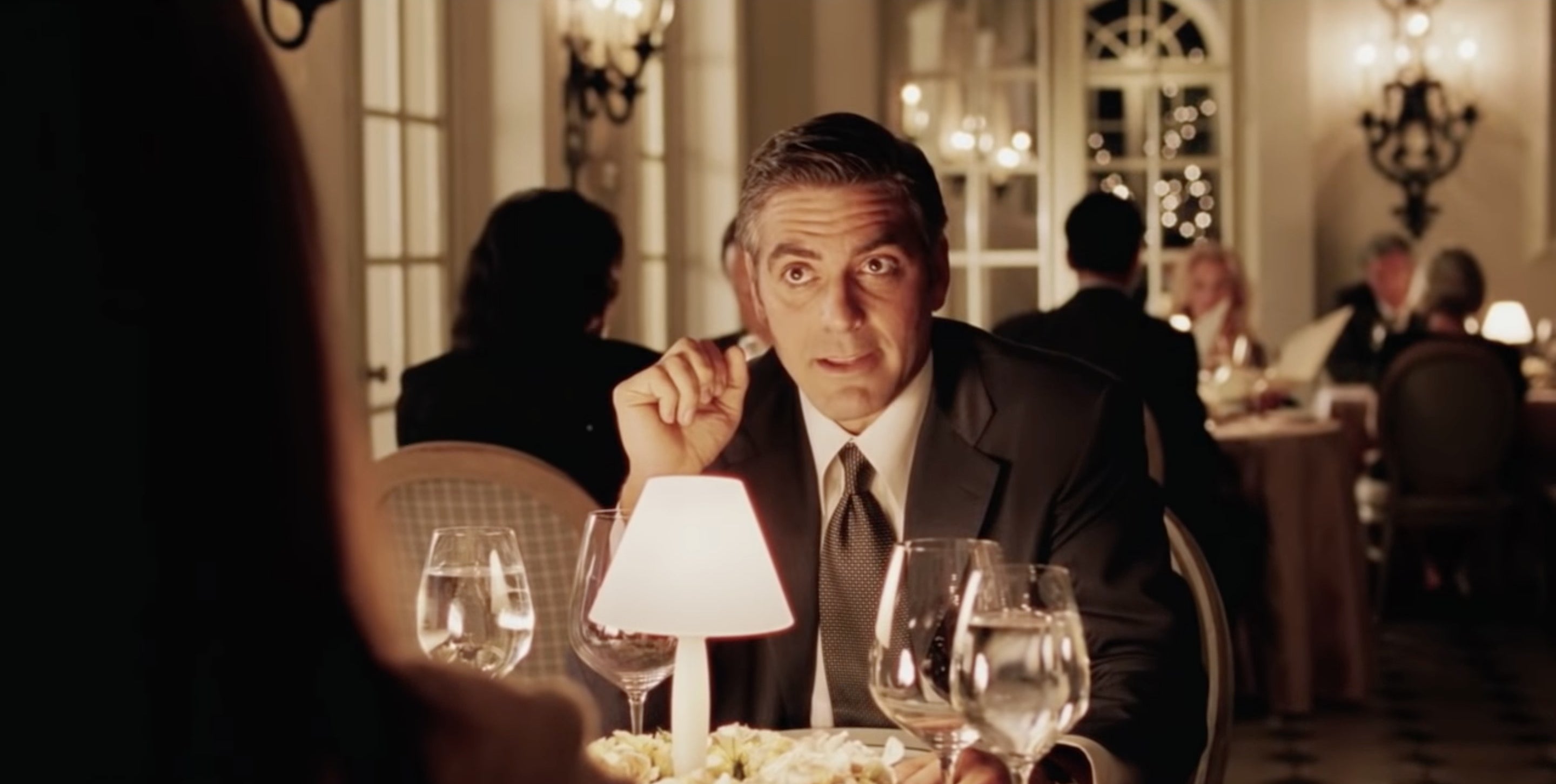 Man speaking over a dinner table in &quot;Intolerable Cruelty&quot;