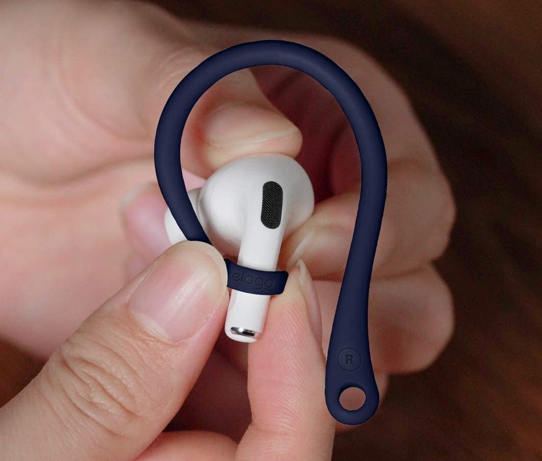 a person putting their airpod into a hook