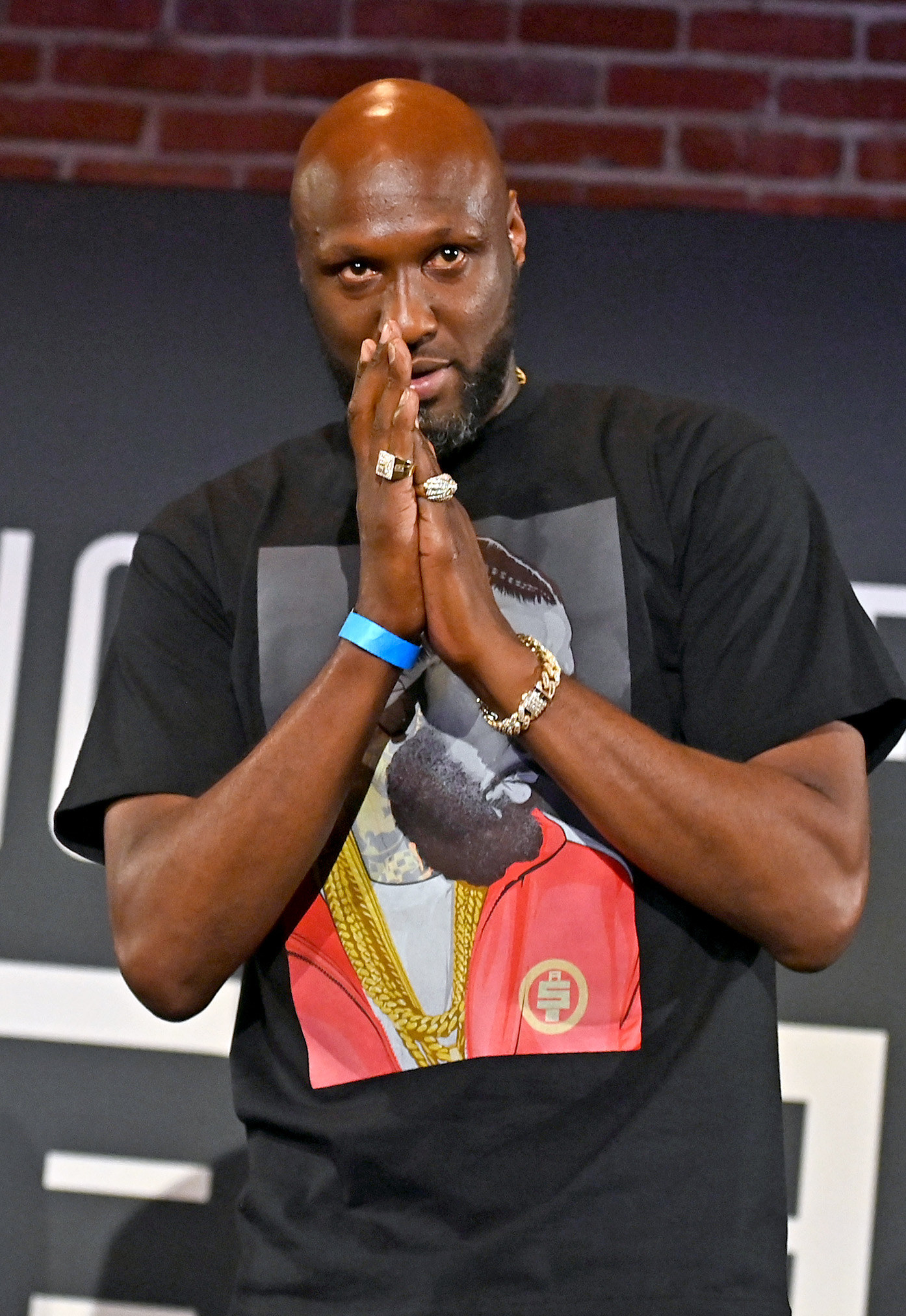 A closeup of Lamar with his hands pressed together