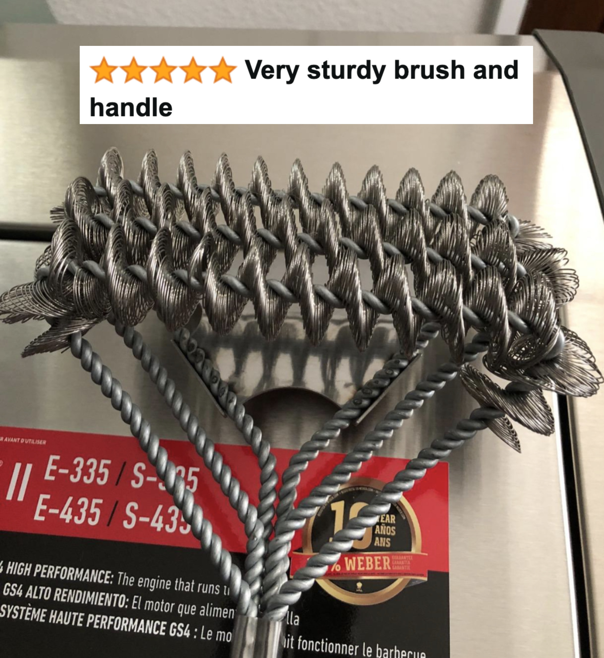 reviewer&#x27;s picture of the grill cleaning brush with five star caption &quot;very sturdy brush and handle&quot;