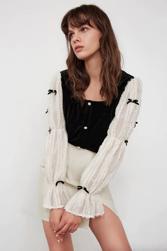 model wearing the black and white long sleeve blouse
