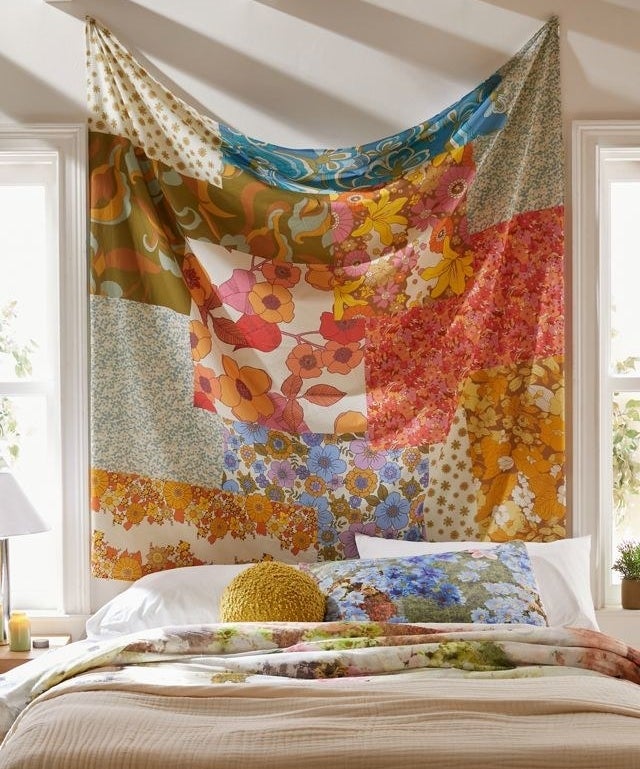 a floral tapestry hanging over a beautiful bed