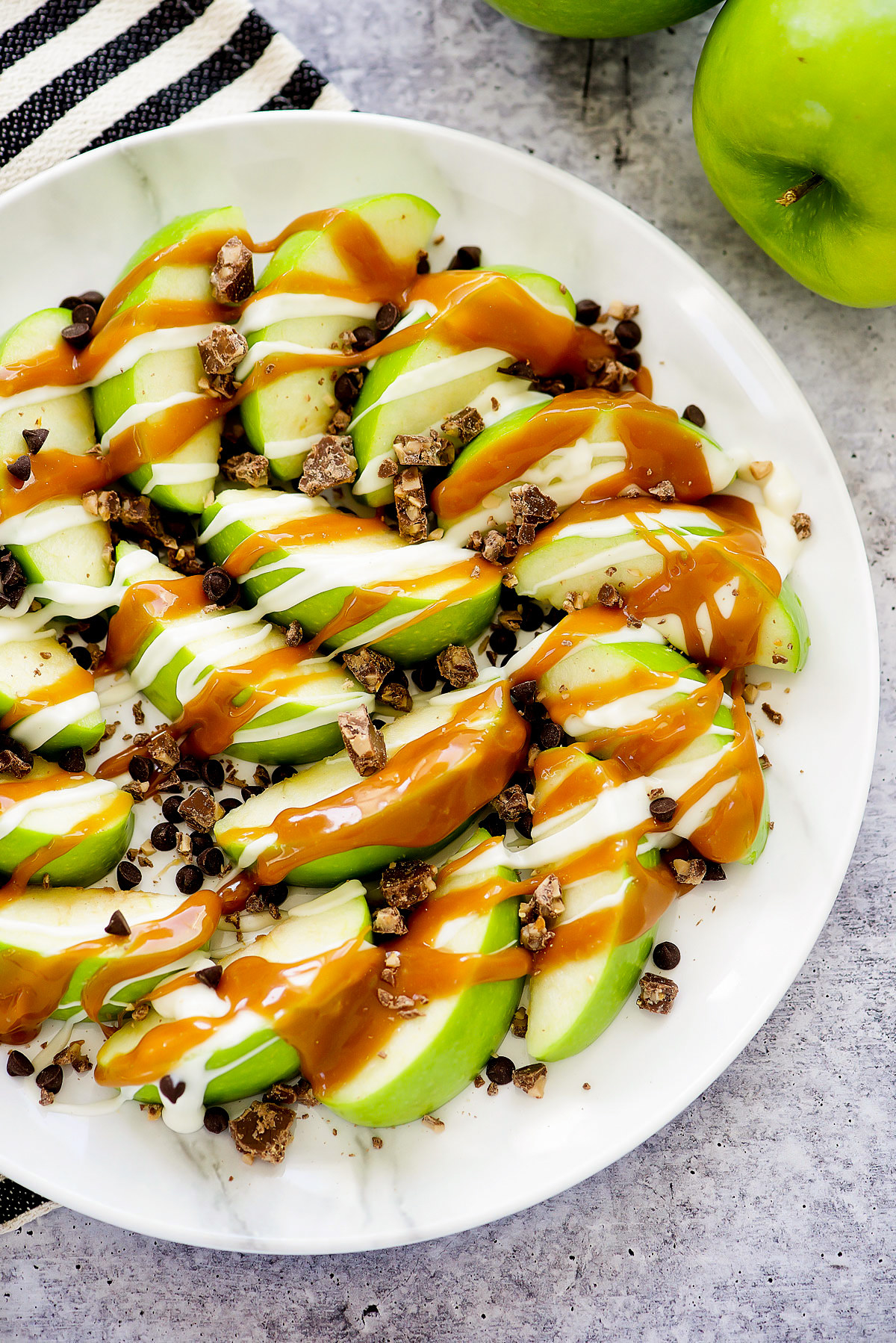 Sliced green apples topped with caramel and heath bar.
