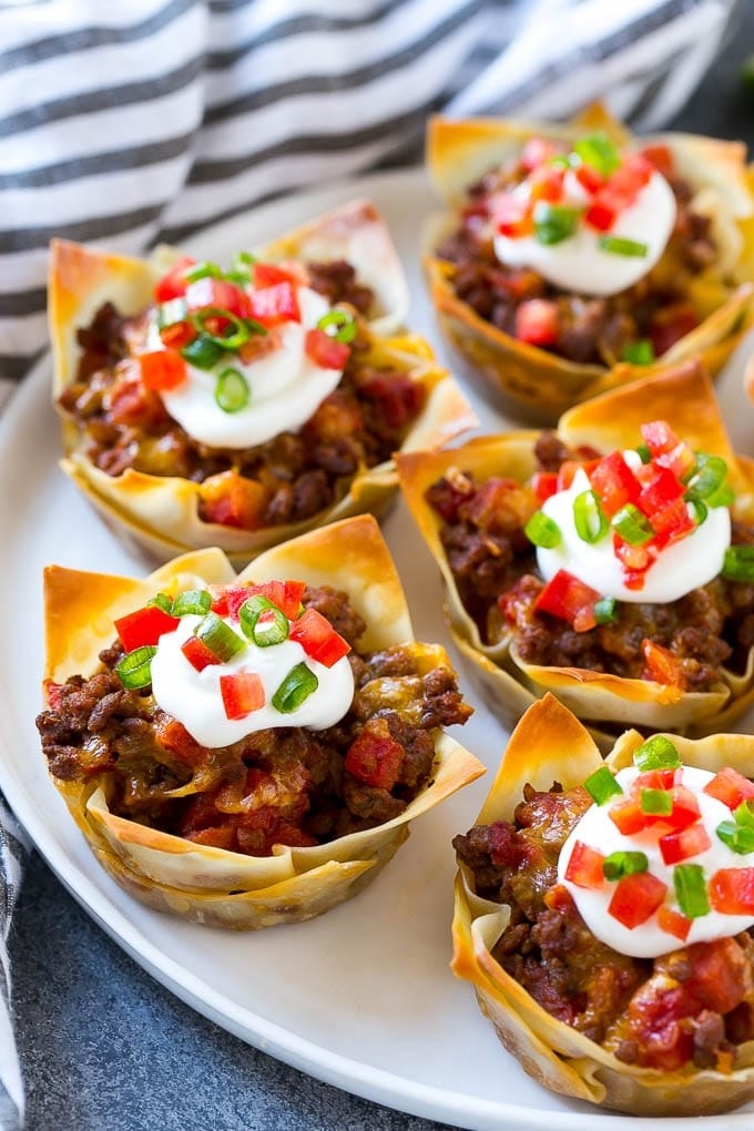 Taco cups filled with beef, cheese, and topped with sour cream.