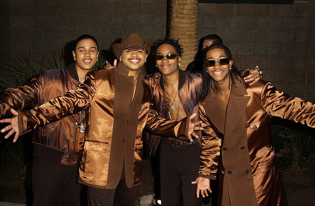 B2K members smiling with their arms raised