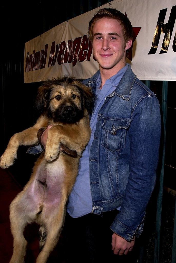 Ryan smiling and holding a fairly large dog with one hand