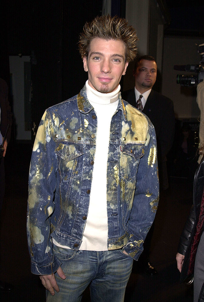 JC Chasez with spiked hair and wearing a motley jeans jacket and jeans