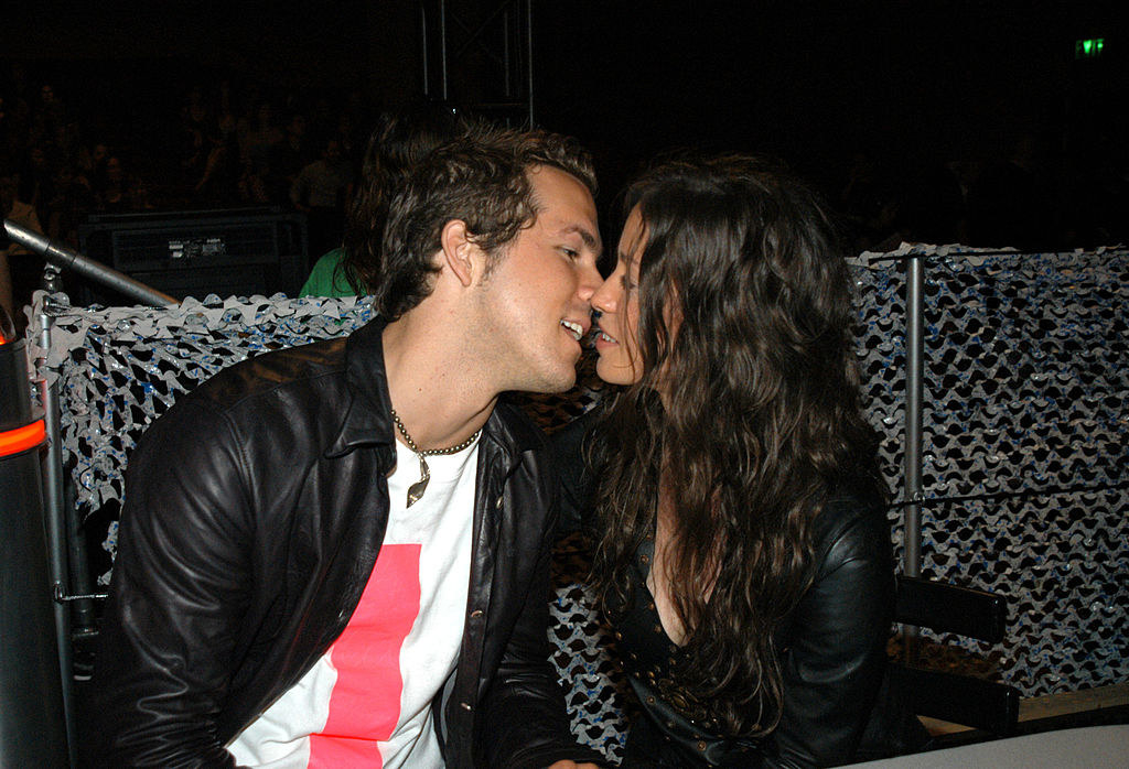 Ryan and Alanis kissing while sitting down