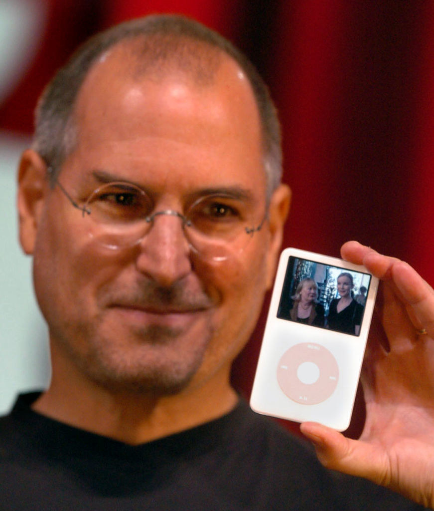 Close-up of Steve smiling and holding up a video iPod