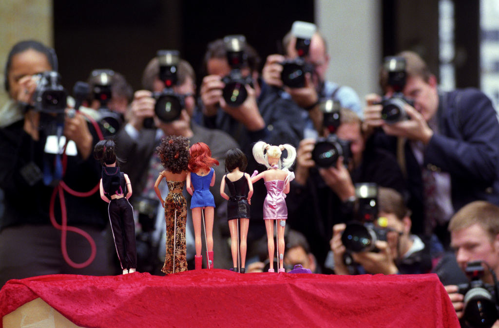Back view of Spice Girls Barbie doll–type dolls on a red platform being photographed