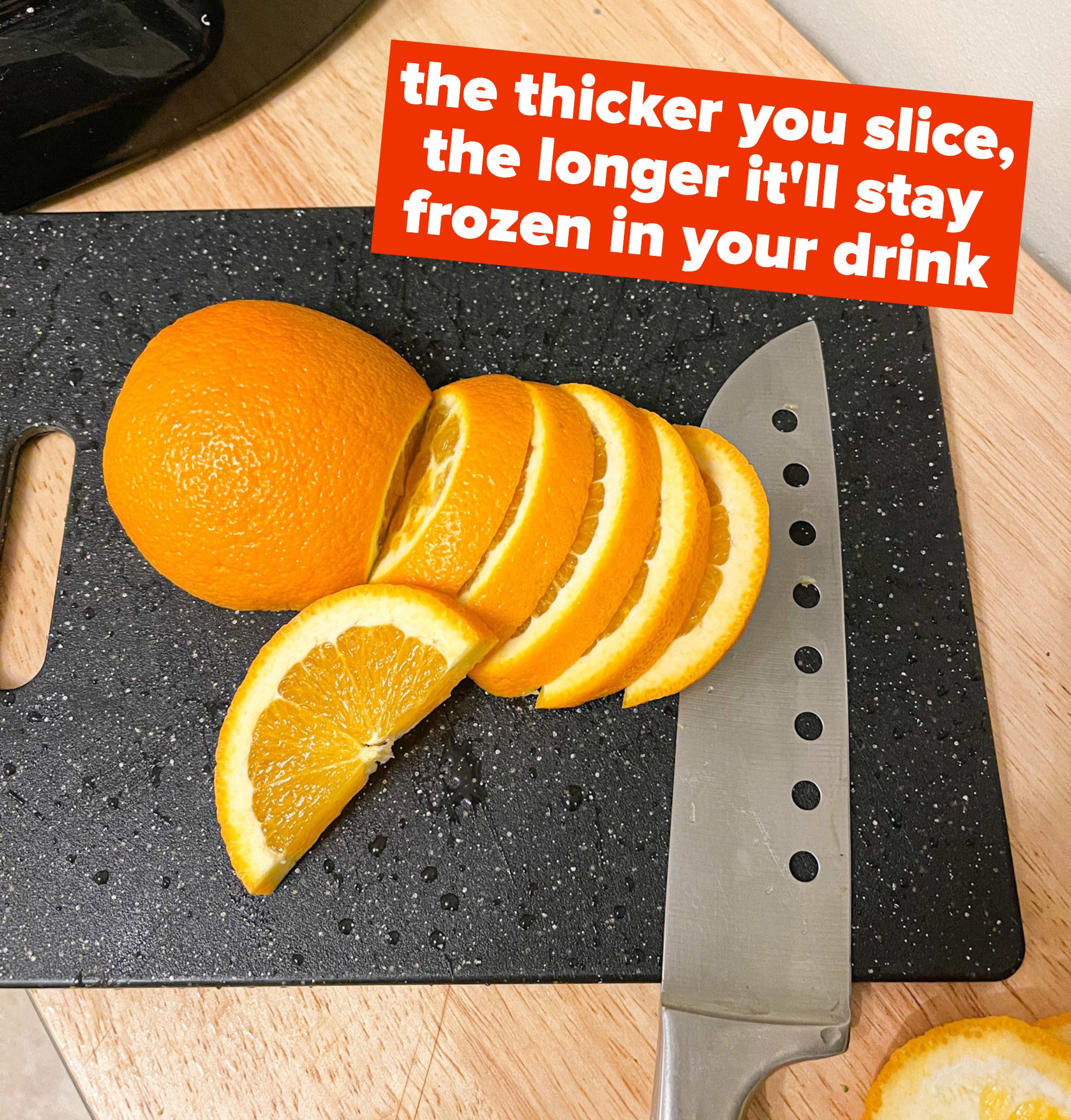Slicing oranges on a cutting board with text: the thicker you slice, the longer it&#x27;ll stay frozen in your drink