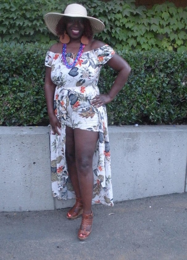 A reviewer wearing a white floral romper dress