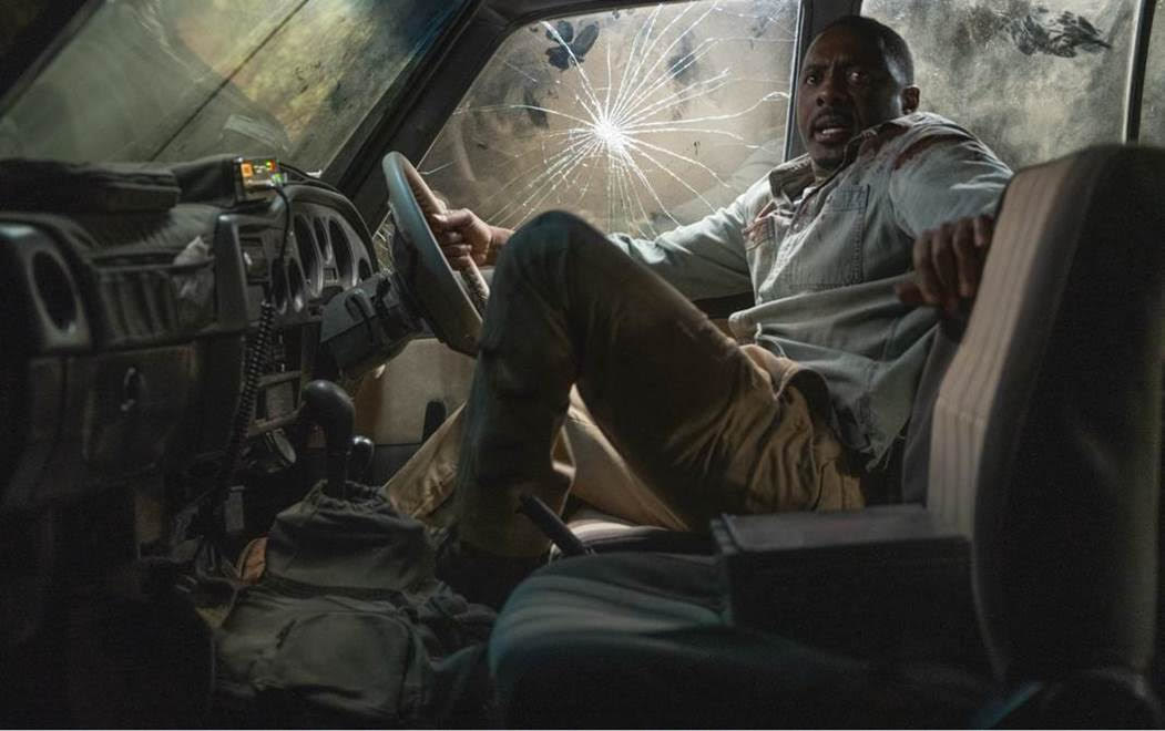 Idris Elba as Dr. Nate Samuels cowing in the corner of a smashed-up van in &quot;Beast&quot;