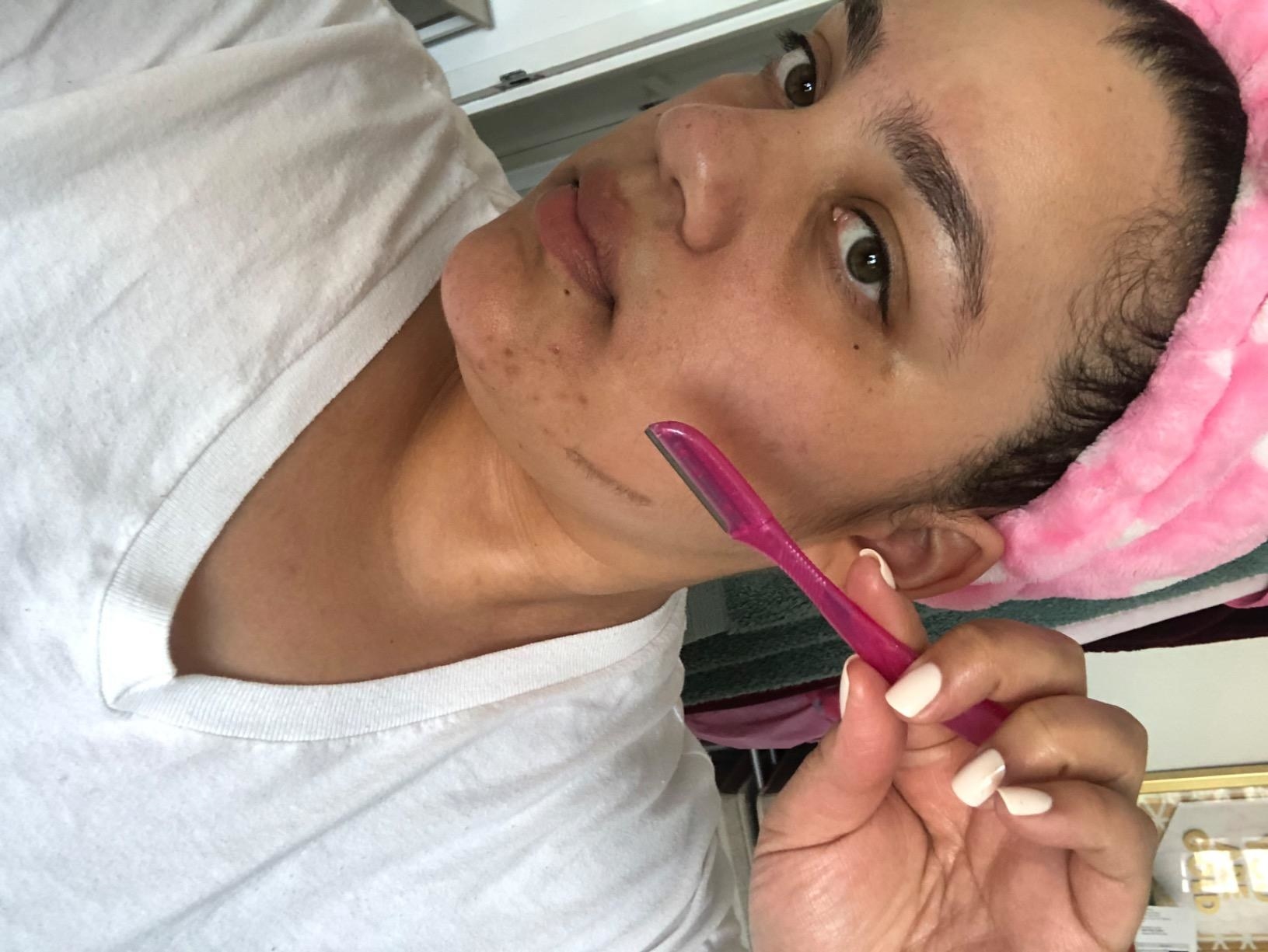 A reviewer&#x27;s holding a pink razor that they are about to use