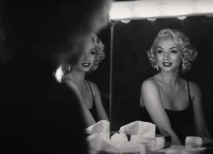 Ana as Marilyn looks in the mirror and smiles
