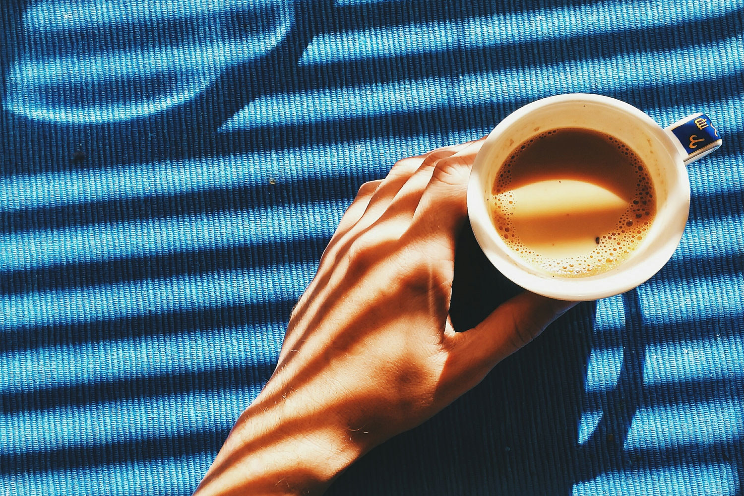 A hand holding a cup of coffee.