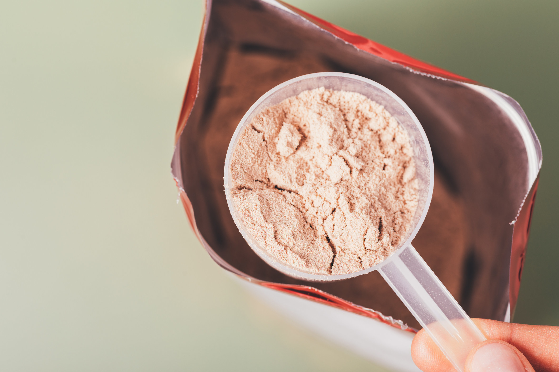 Measuring protein powder with a spoon.