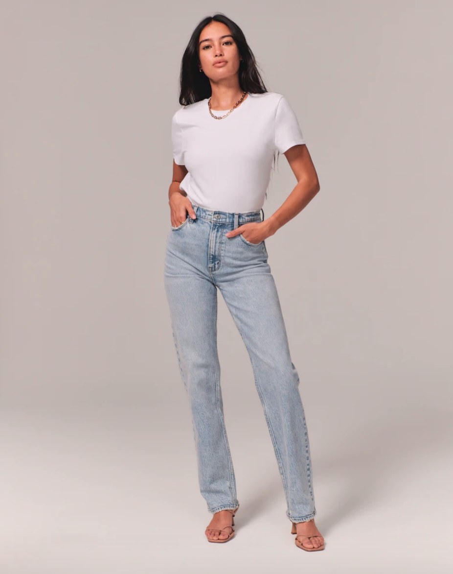 Model wearing light wash straight leg jeans with white tee