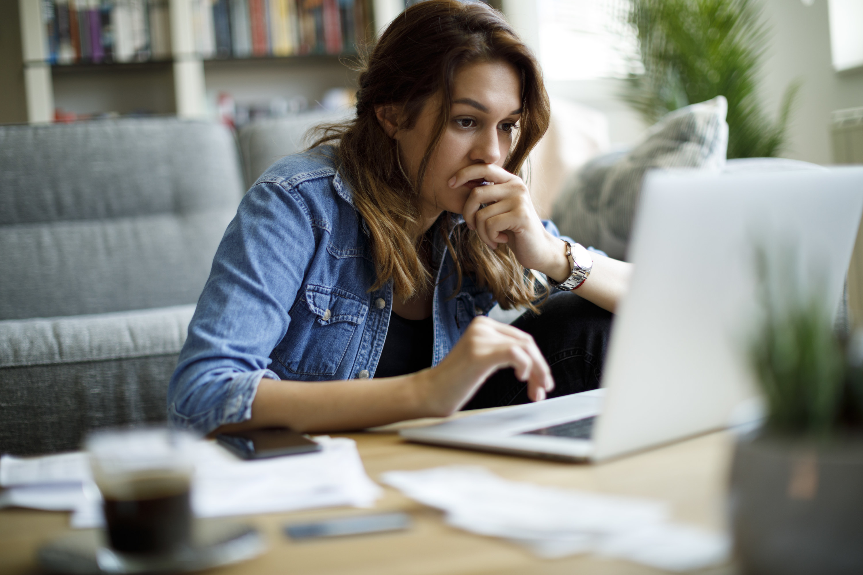 young woman looking at her finances on her laptop