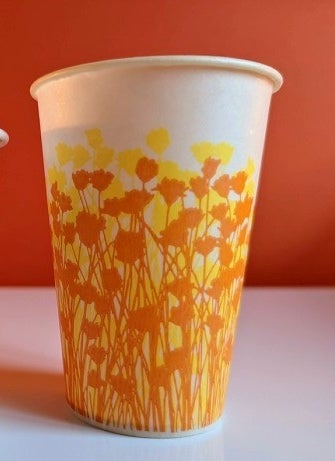 A paper cup covered in drawings of flowers