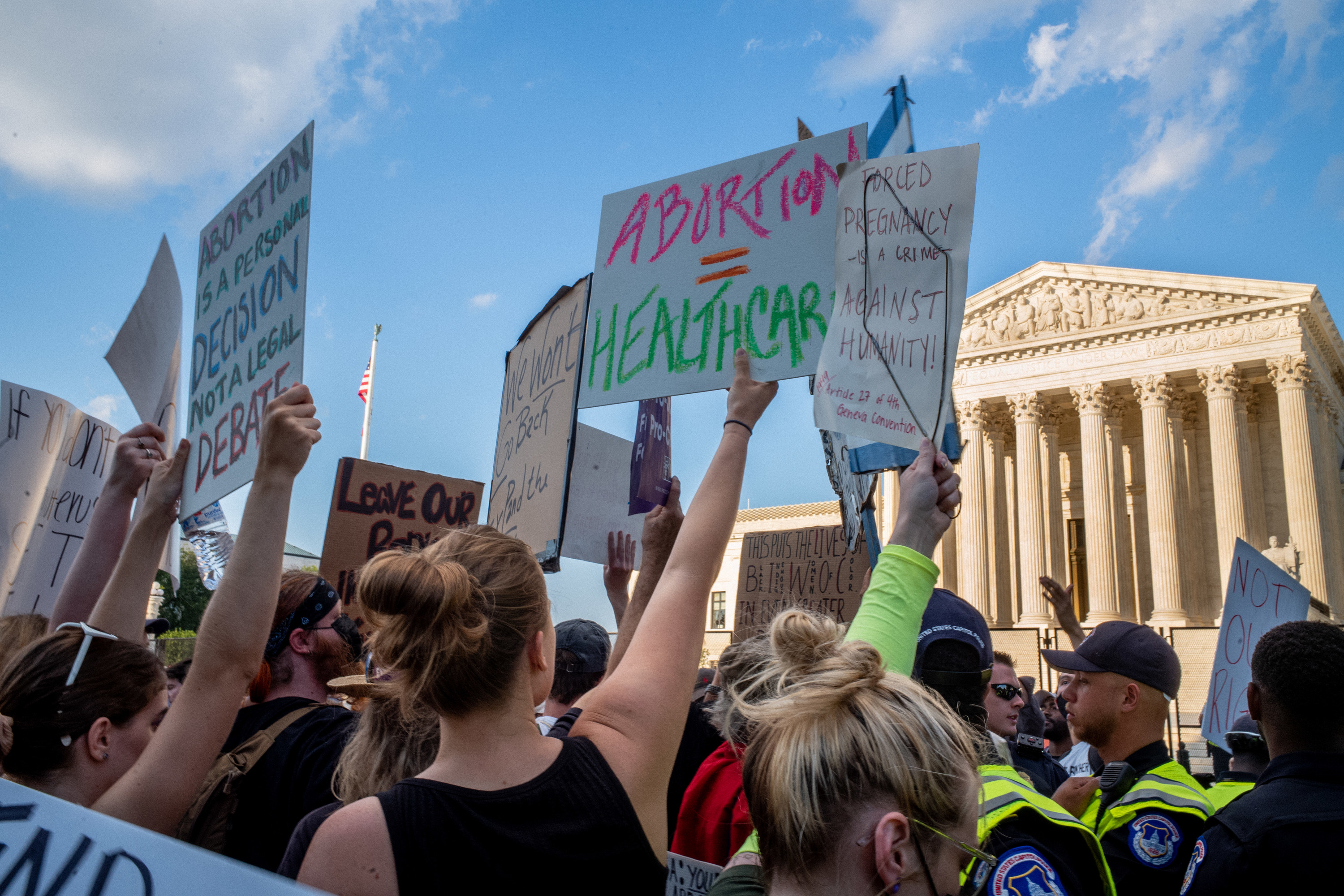 Protesters outside the Supreme Court holding up signs like &quot;Abortion = healthcare&quot;