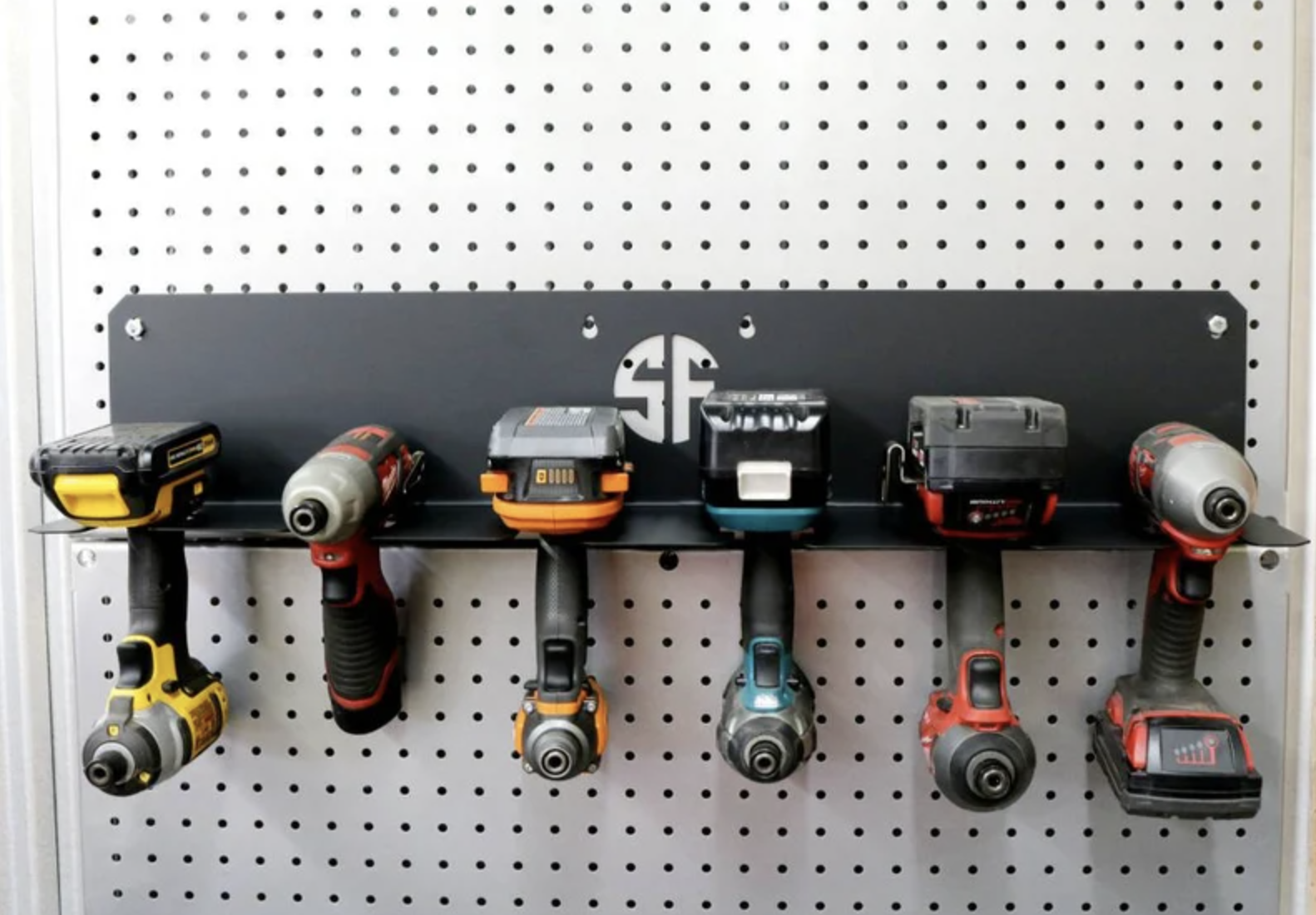 Six power tools are mounted to a wall