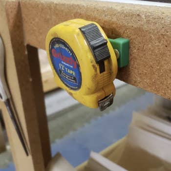 A measuring tape is shown mounted to a work bench