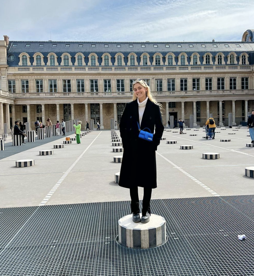 Clair standing on a block in front of a museum