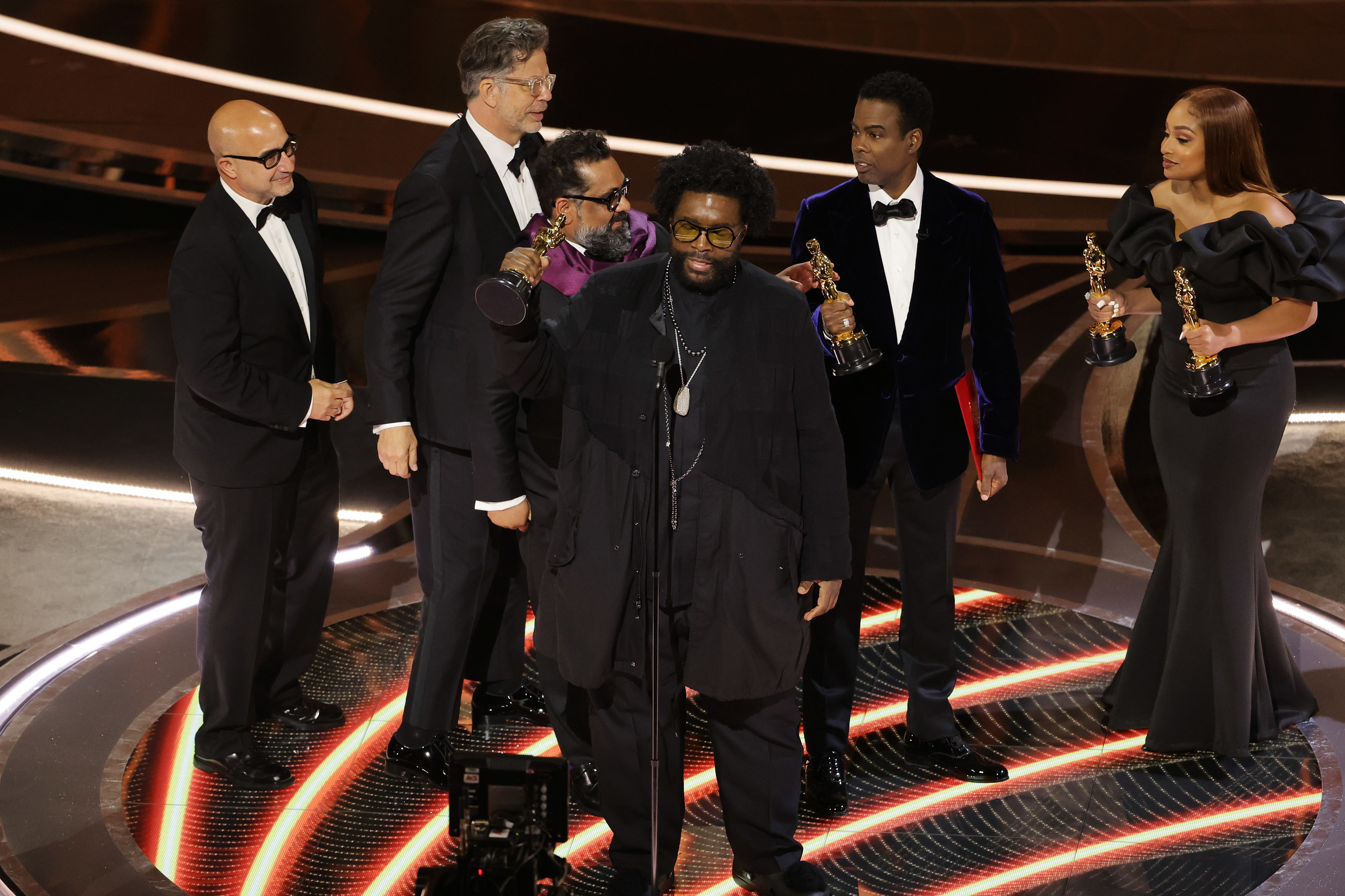 Questlove accepting his Oscar with Chris and others behind him