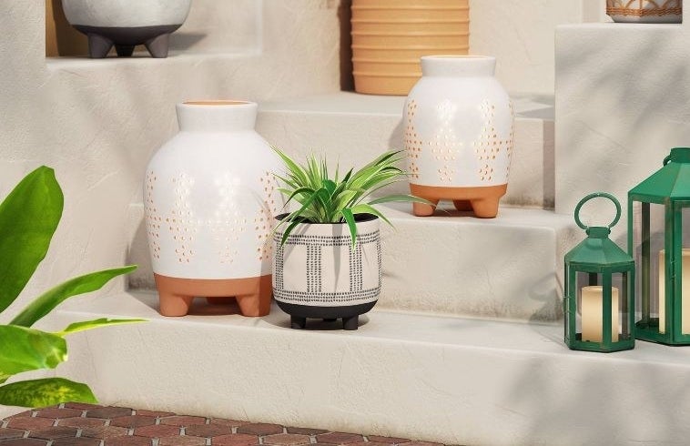 Two large white and brown terracotta outdoor lanterns sitting on steps
