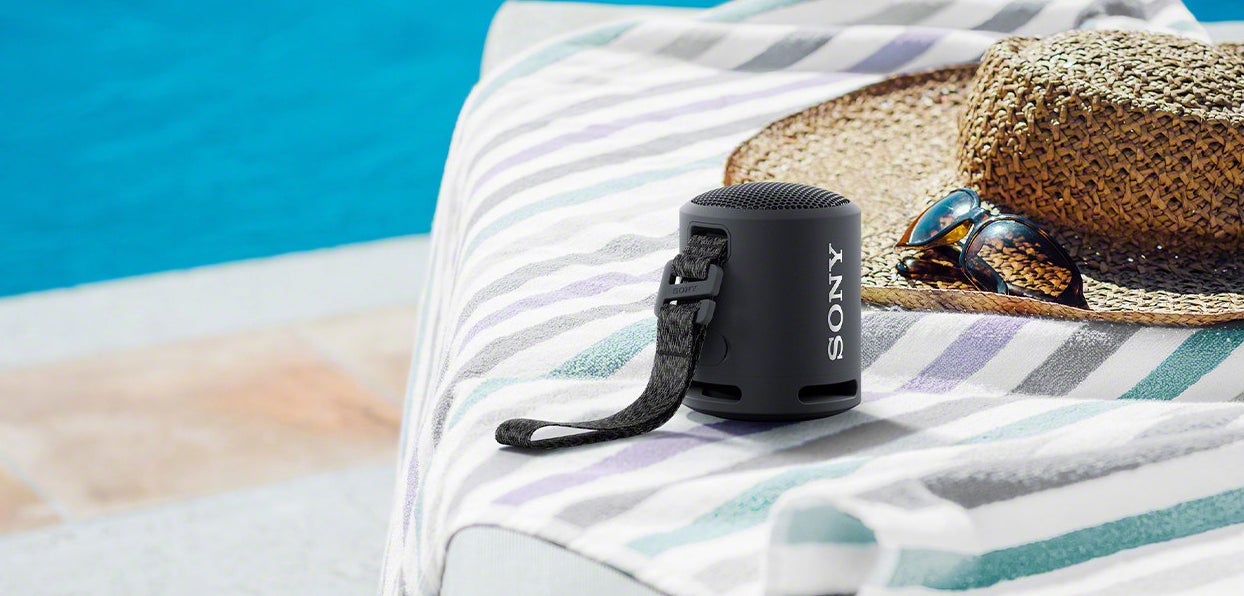 a black waterproof bluetooth speaker near a pool