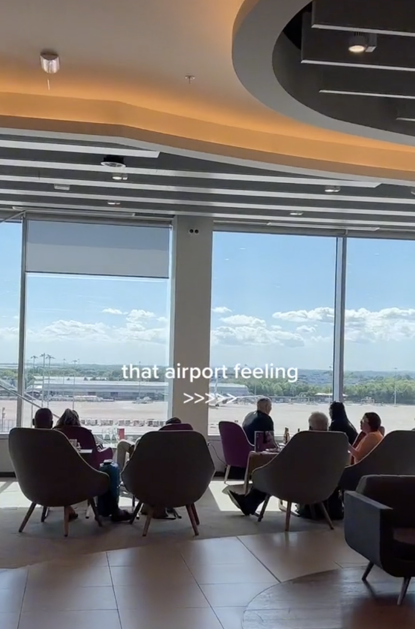 A screenshot of a TikTok, it shows people sitting in an airport looking out the windows, overlaid text reads &#x27;that airport feeling&#x27;