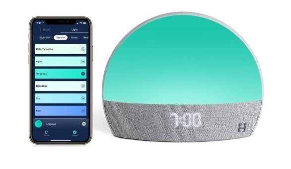 the Hatch machine with a turquoise light beside a smartphone open to the app
