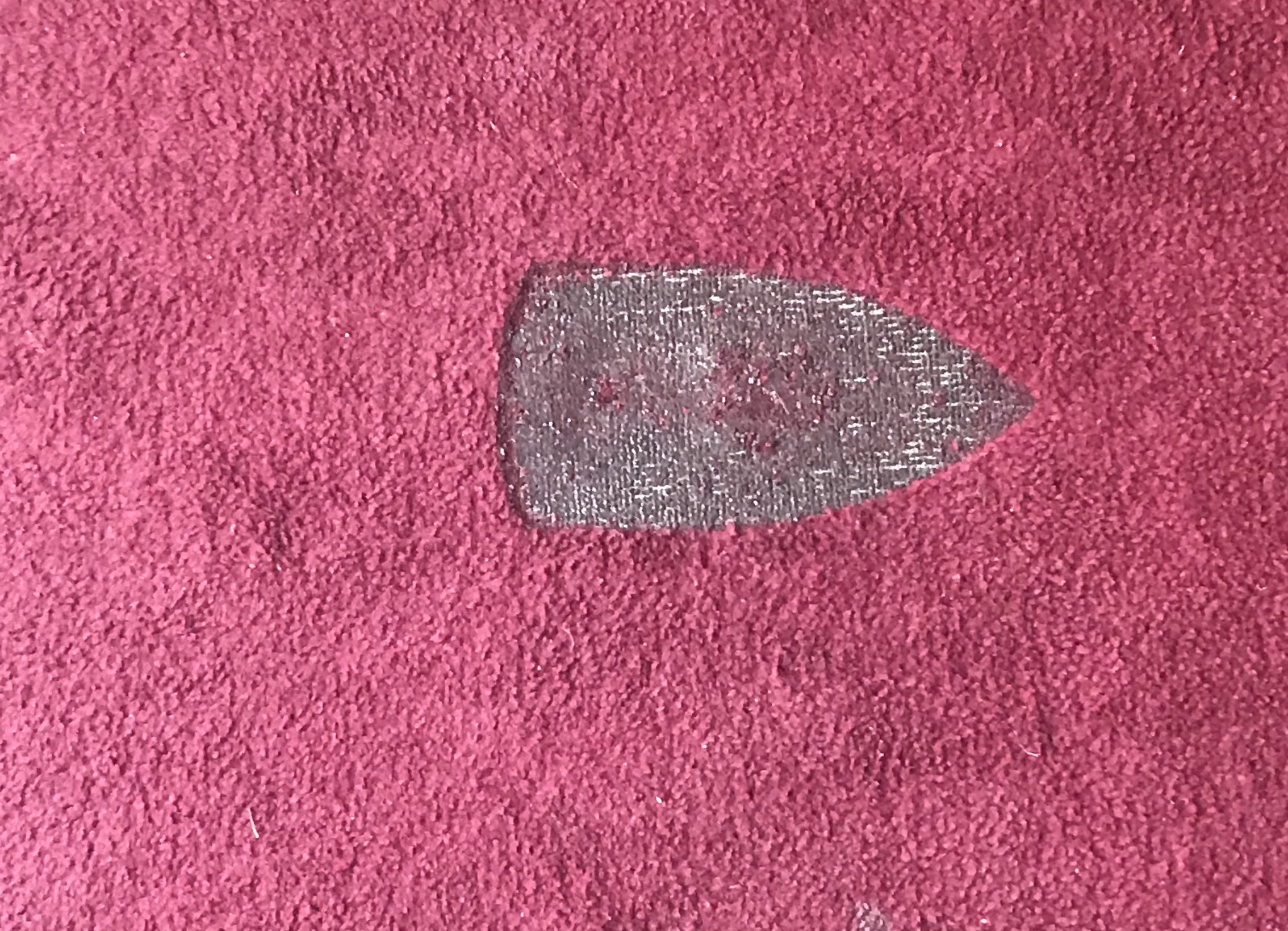 a clothes iron shaped burn mark in a carpet