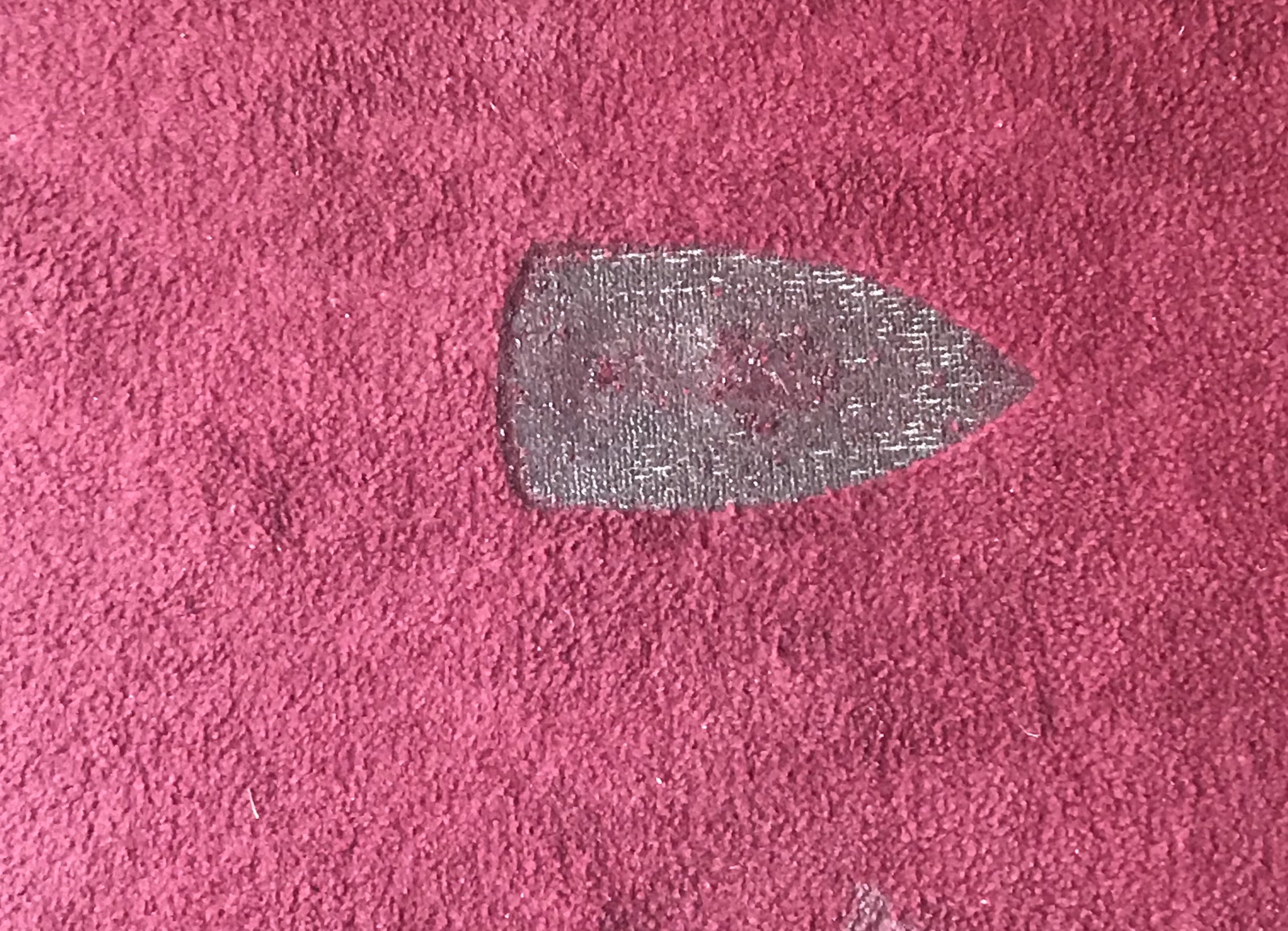 a clothes iron shaped burn mark in a carpet