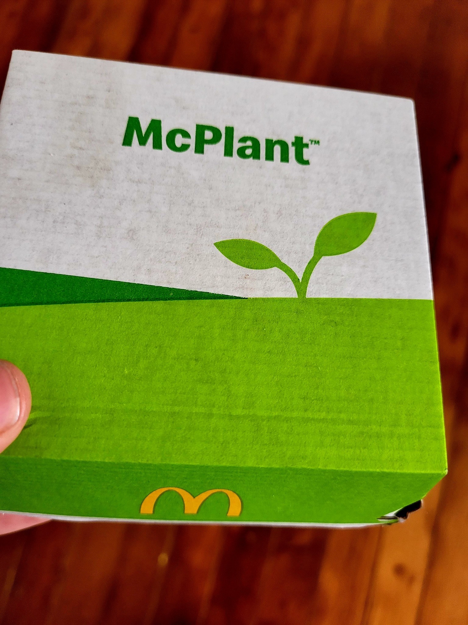 A hand holding a McPlant burger box