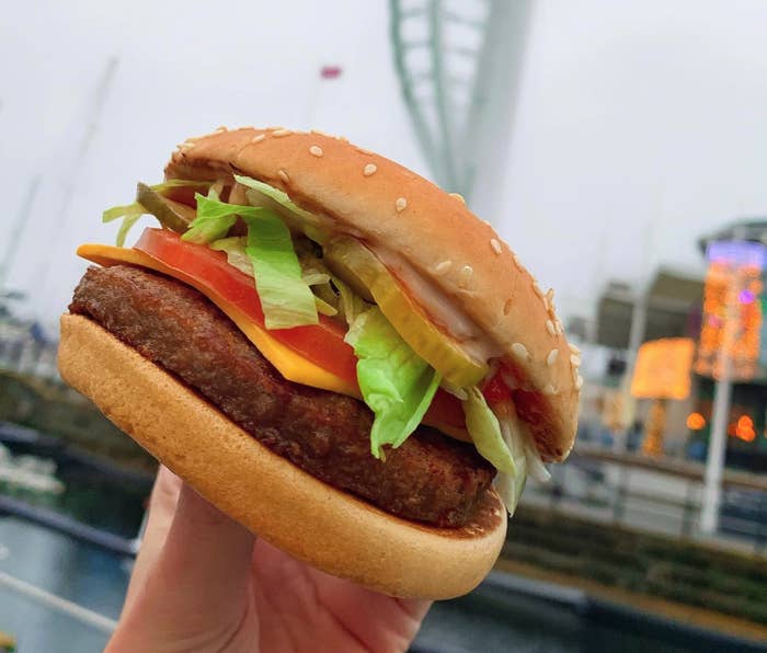 A hand holding a McPlant burger