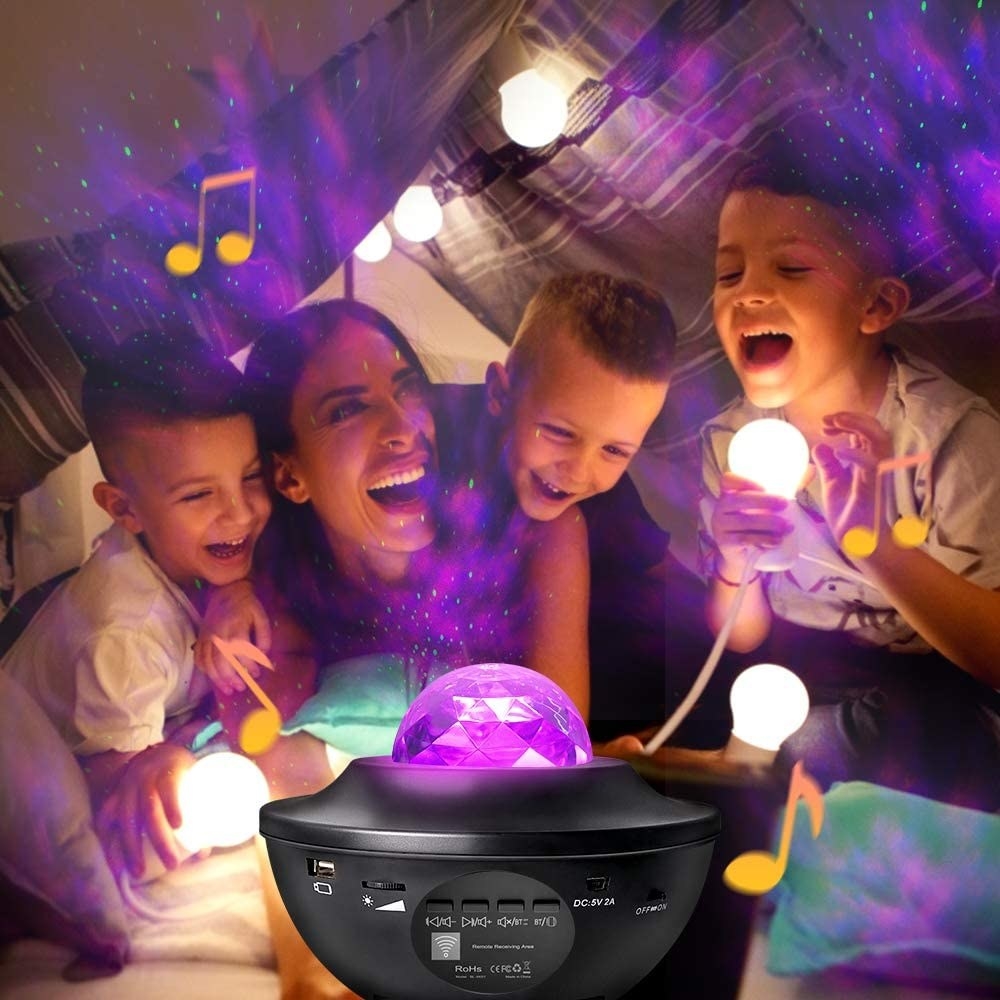 A family in a blanket fort with the star projector