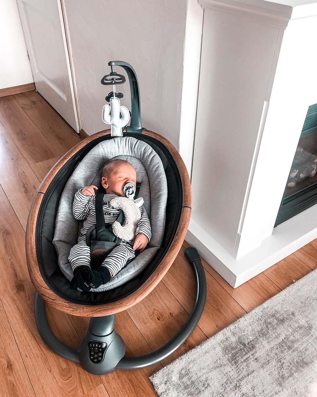 A baby inside the baby chair in a living room