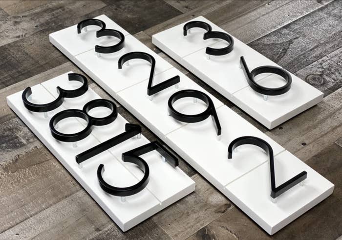 Black house numbers on white boards are shown